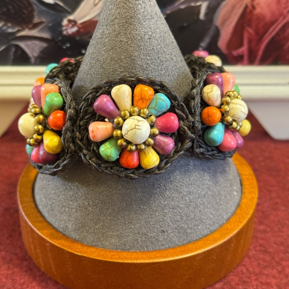 Braided corded bracelet w/multi-colored beads arranged in floral pattern
